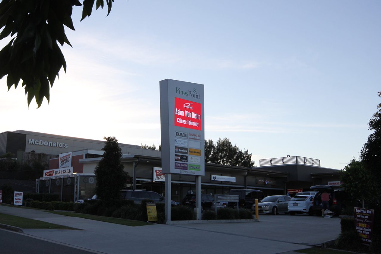 Red advertising on the Pines Point sign outside the retail complex.