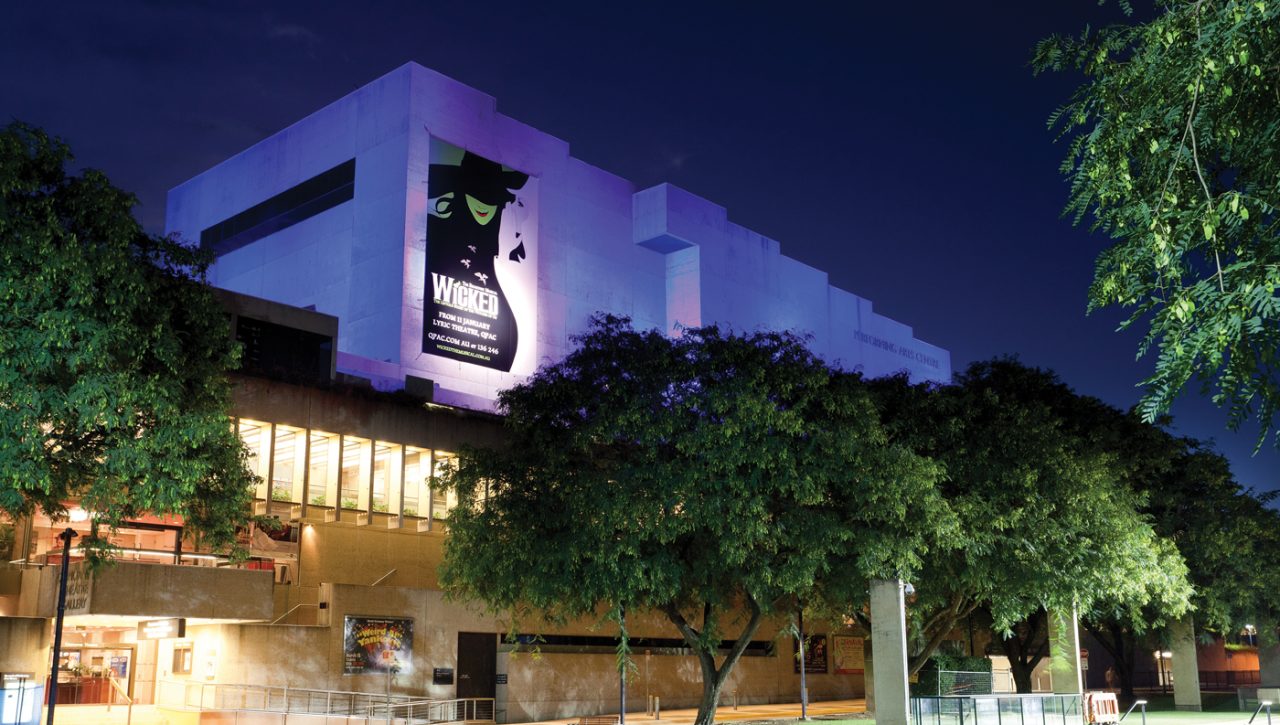 Pale purple lighting across the QPAC facade at night.
