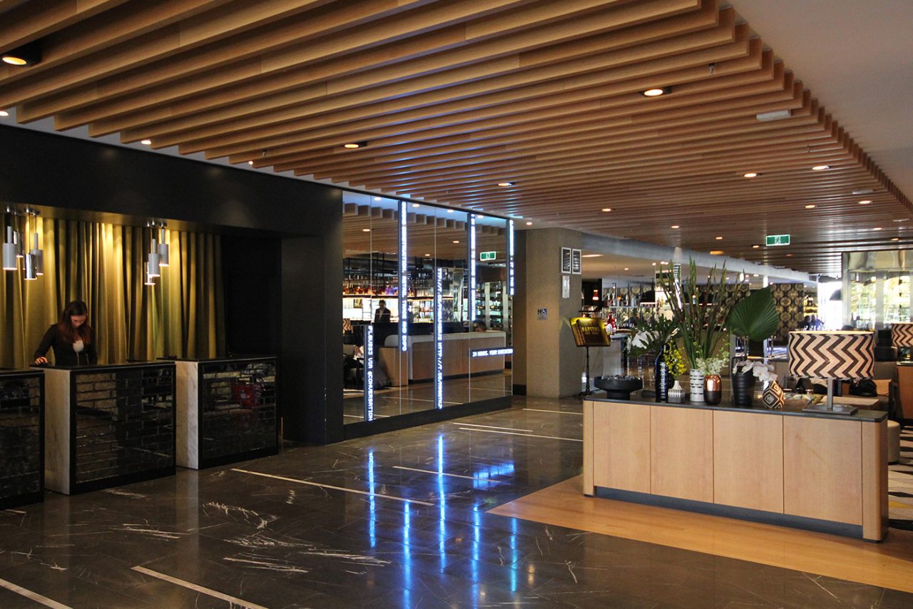 Illuminated message strips beside the reception area at QT Hotel.
