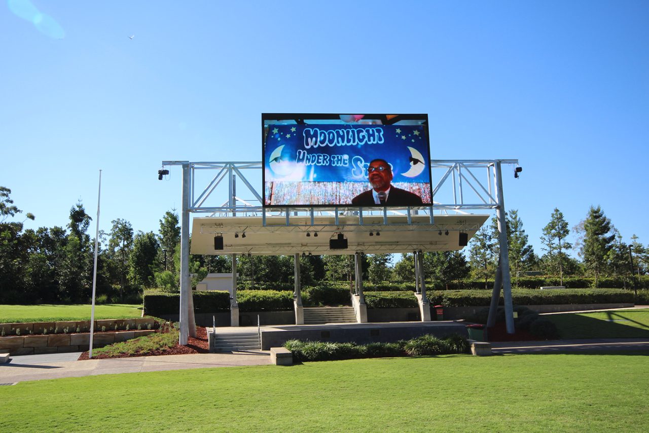 Digital video display above Robelle Domain's stage in daylight.