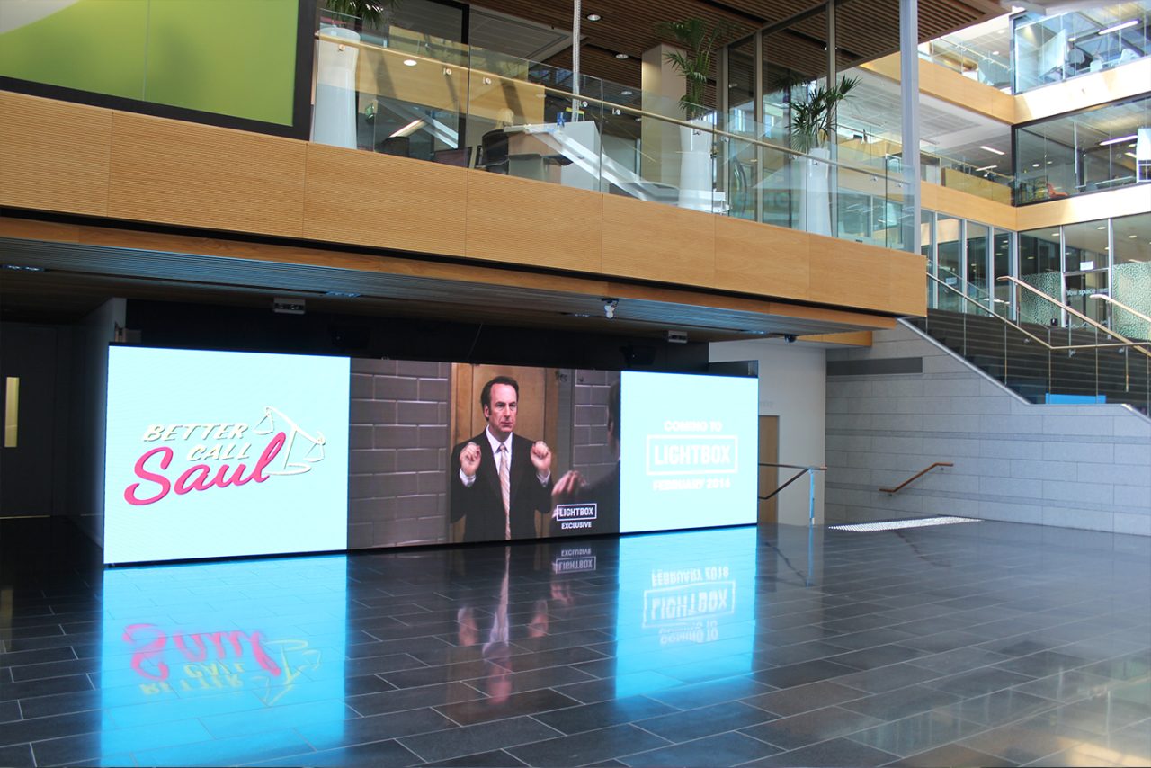 Wide video advertising screen beneath the mezzanine in Spark's headquarters foyer.