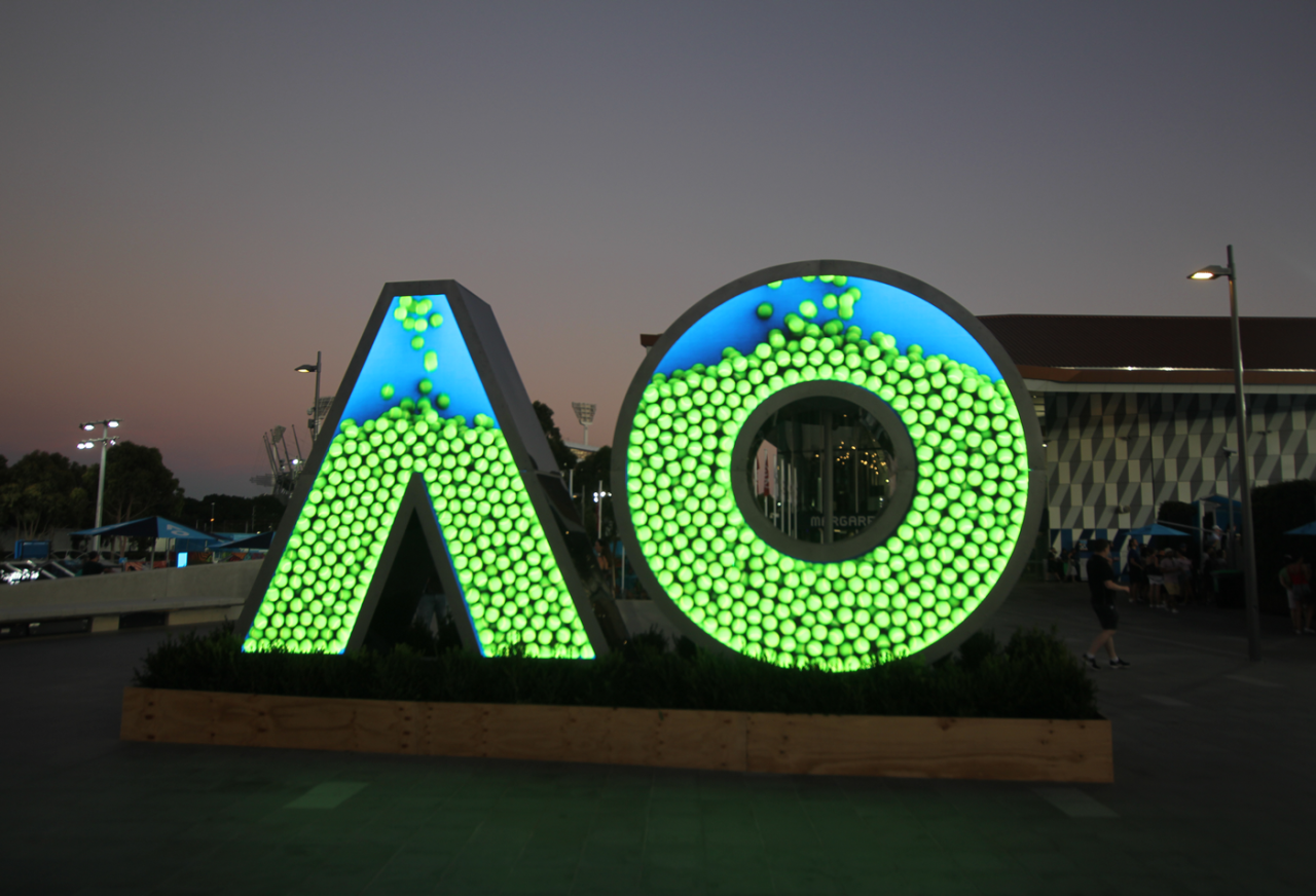 AO-shaped digital sign displaying green patterned graphics.