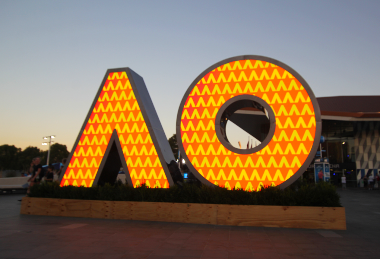AO-shaped digital sign filled with an orange geometric pattern.