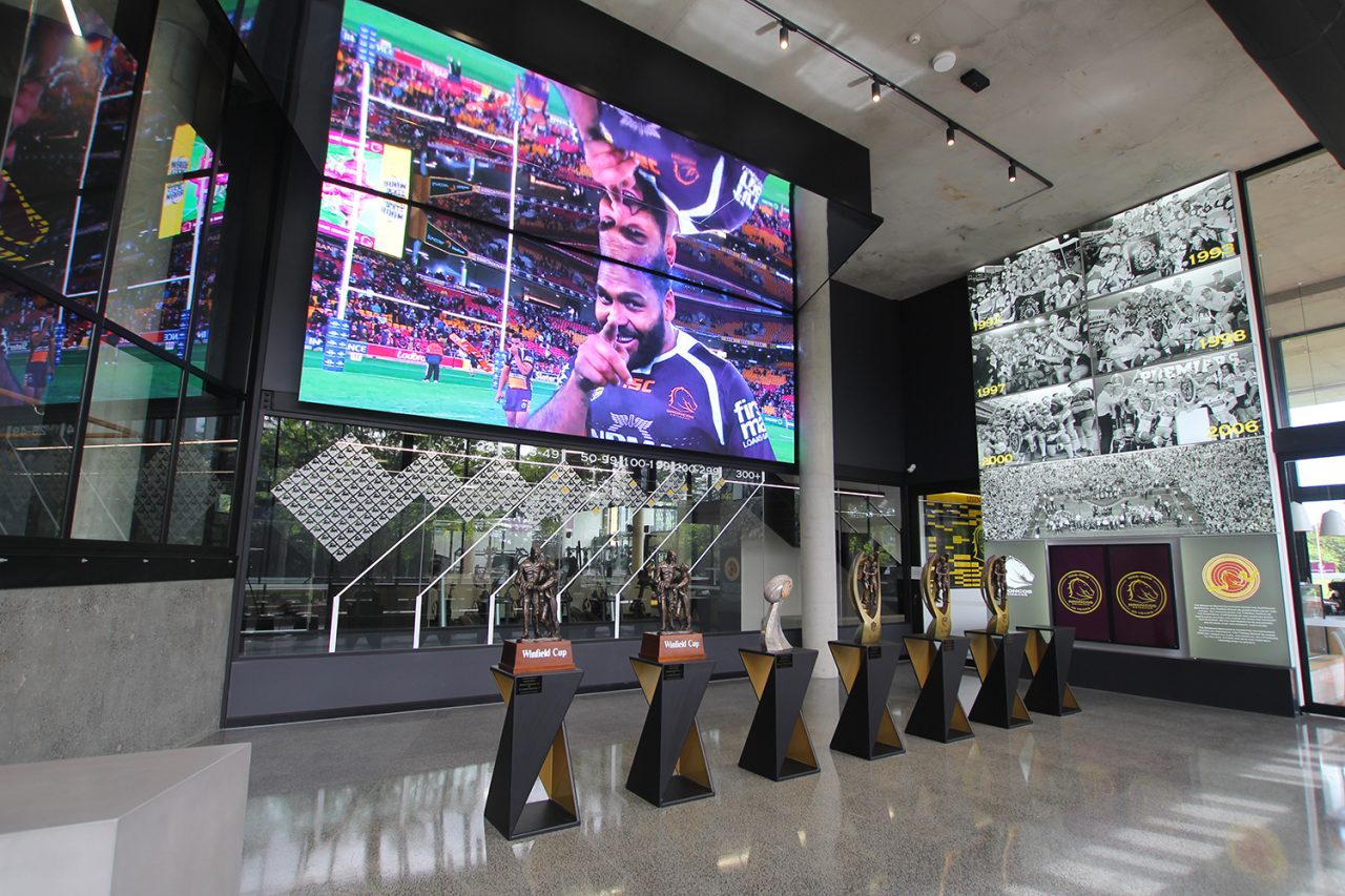 Wide view of the Broncos foyer screen and trophies.