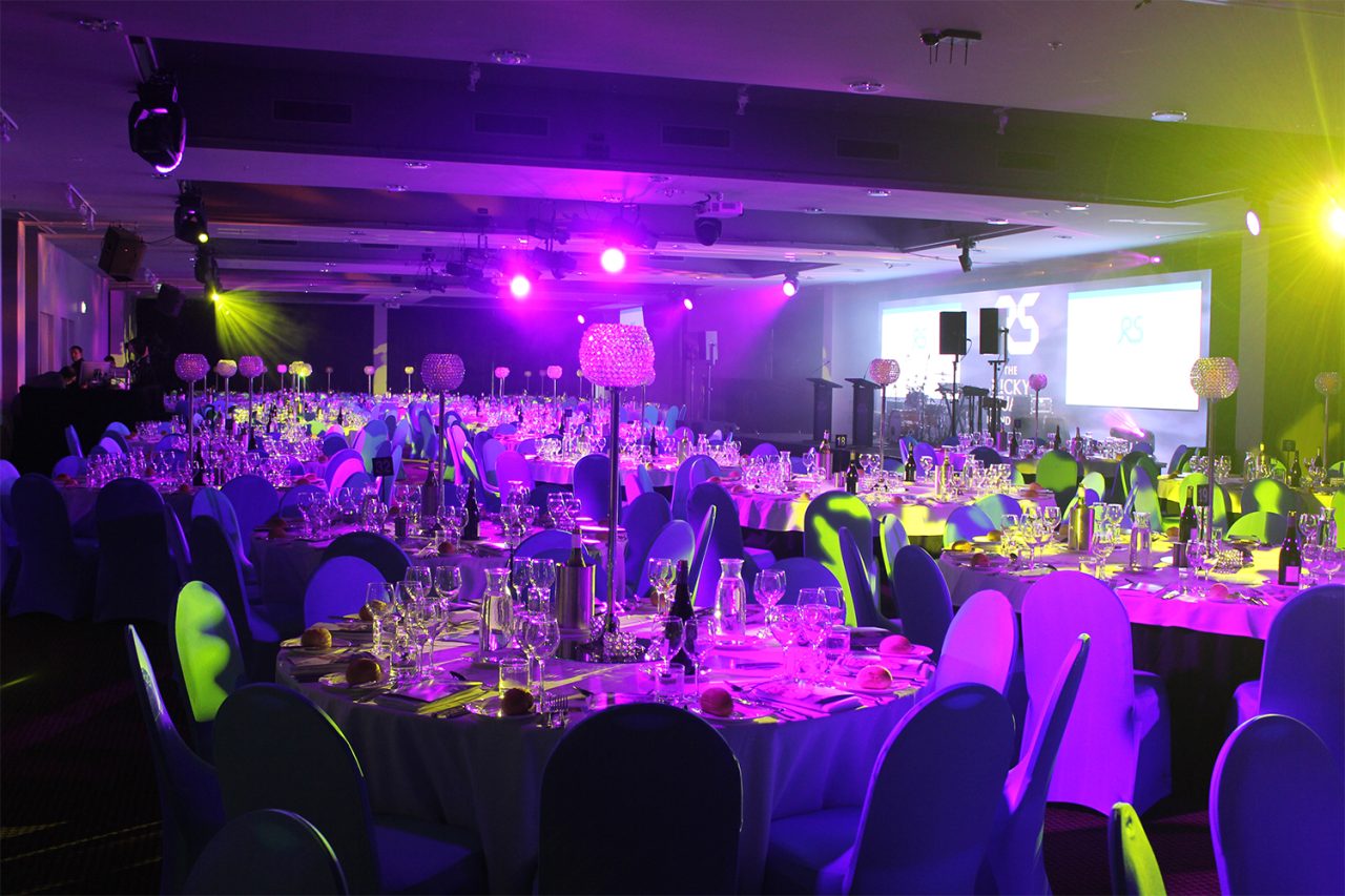 Banquet tables and guests under colourful lighting at the foundation gala.