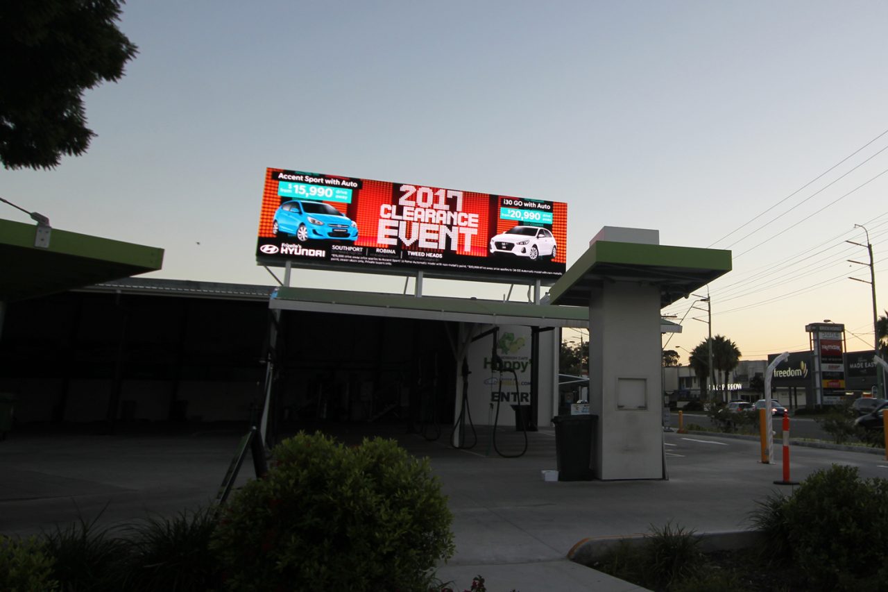 Event advertising on the digital billboard above Hoppy's car wash bays.
