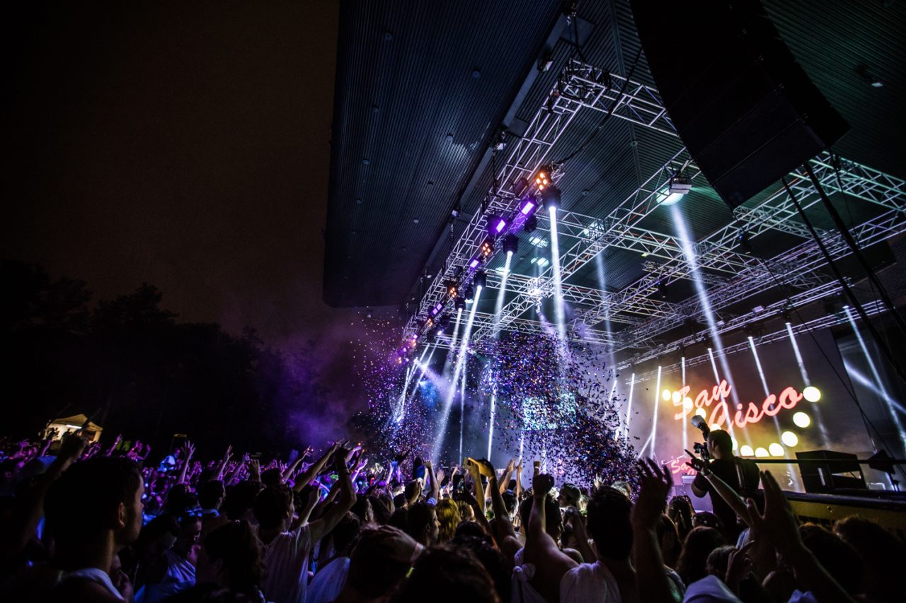Side view of the crowd and white stage beams at Togafest 2018.