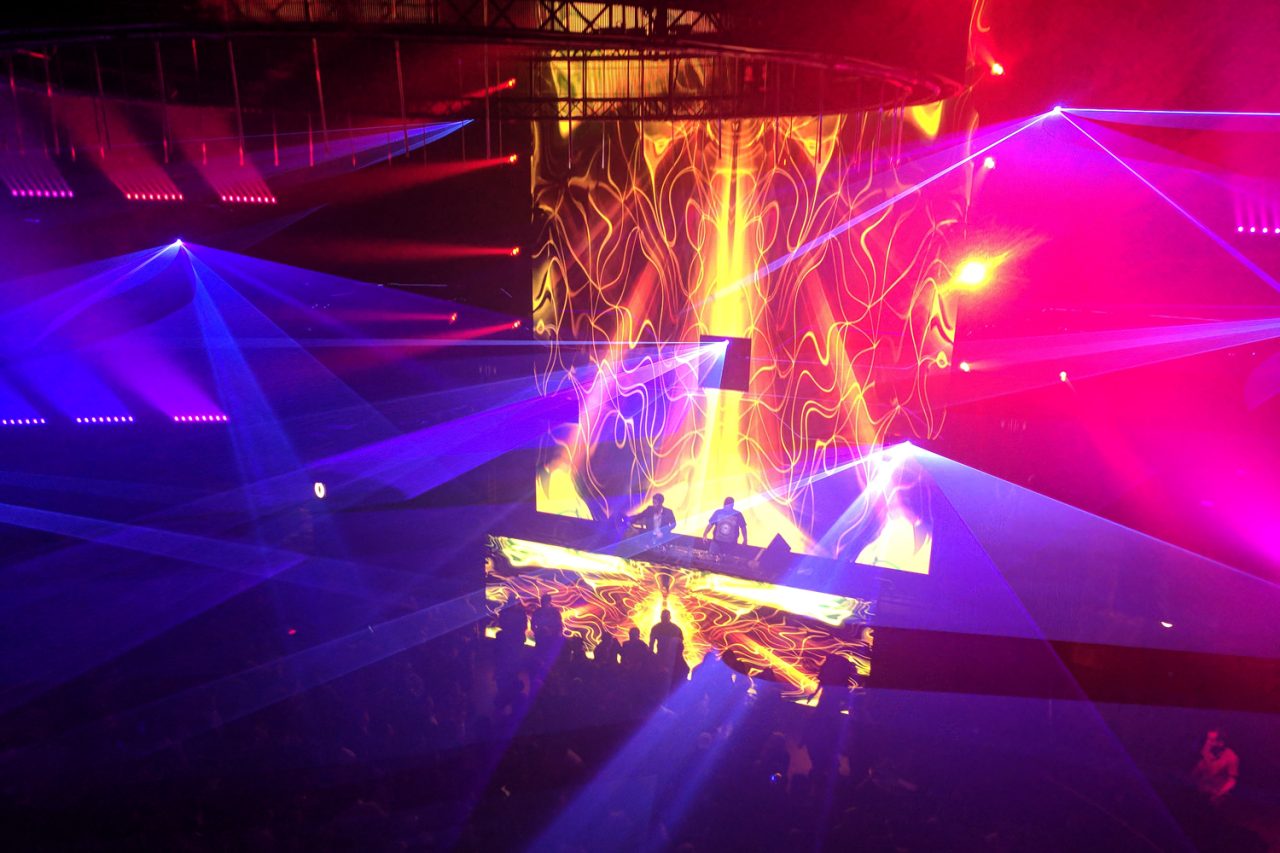 Gold video imagery and purple beams around the Cove Manila stage.