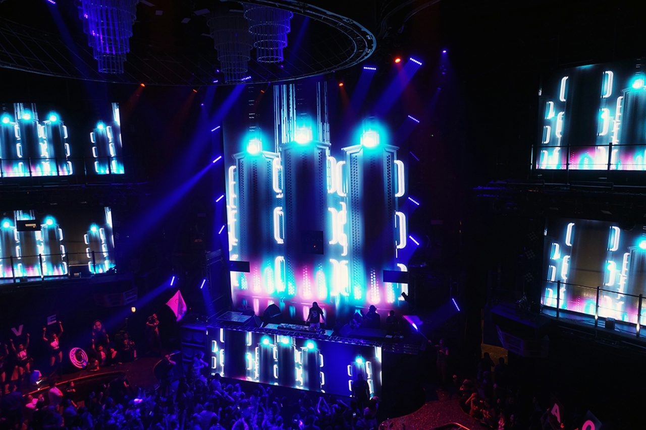 Bright vertical video columns above the crowd at Cove Manila.