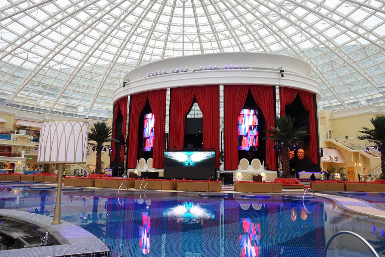 Vertical video displays around the poolside pavilion beneath Okada Manila's glass roof.