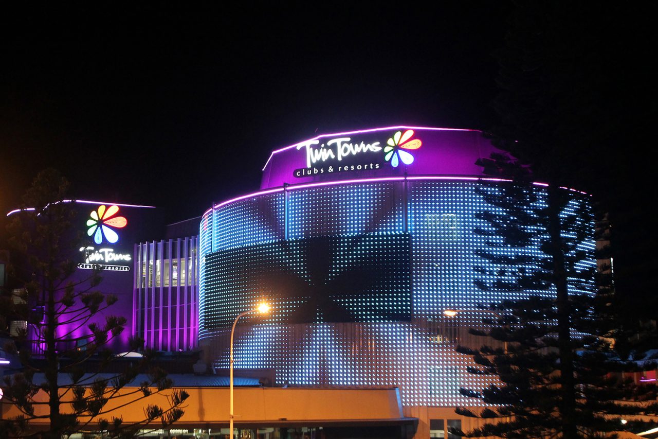 Blue and white patterns across the Twin Towns facade beneath its illuminated sign.