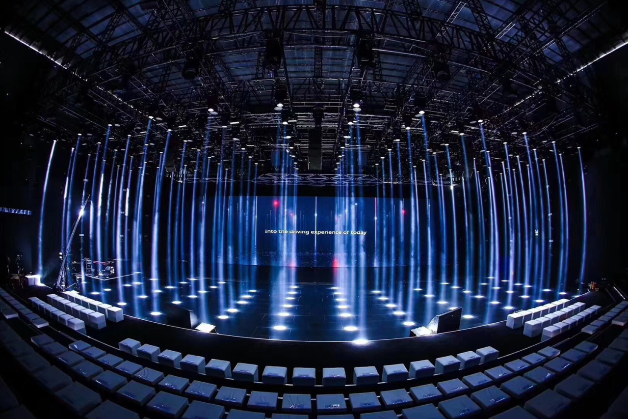 Rows of vertical blue-white beams around the Audi Q8 launch stage.