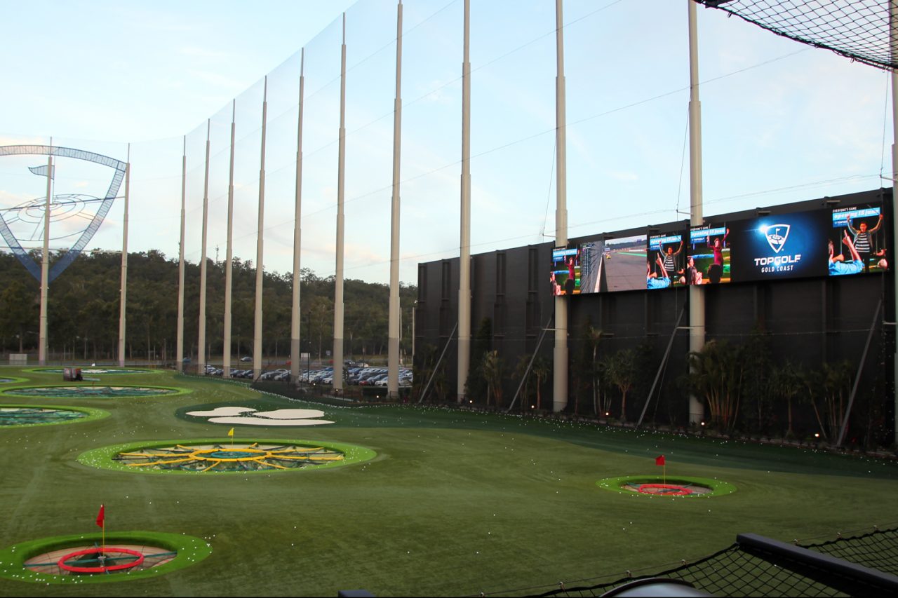 Topgolf driving range with LED screens along the far boundary.