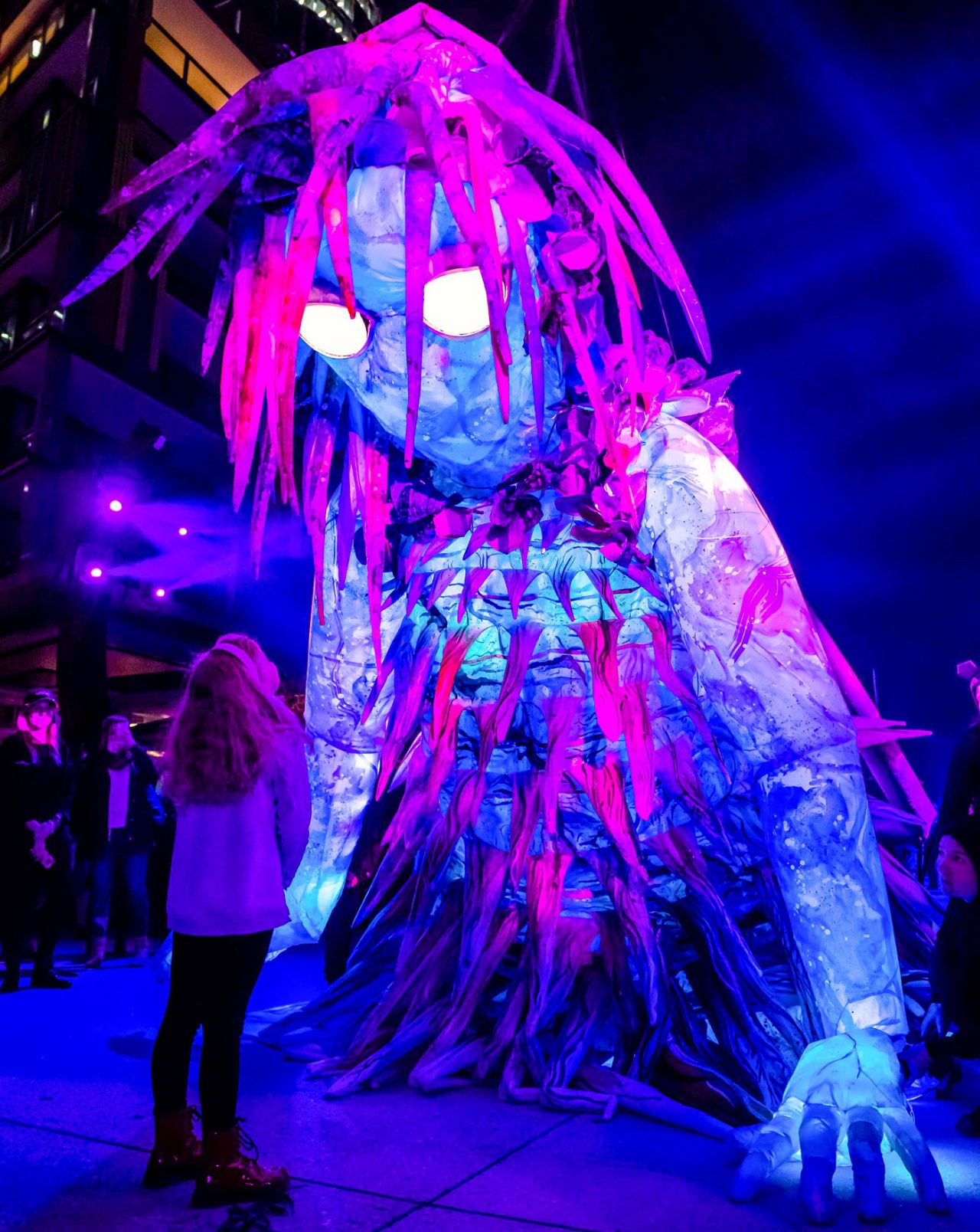 Large illuminated figure glowing purple and blue in The Liminal Hour at Vivid Sydney.