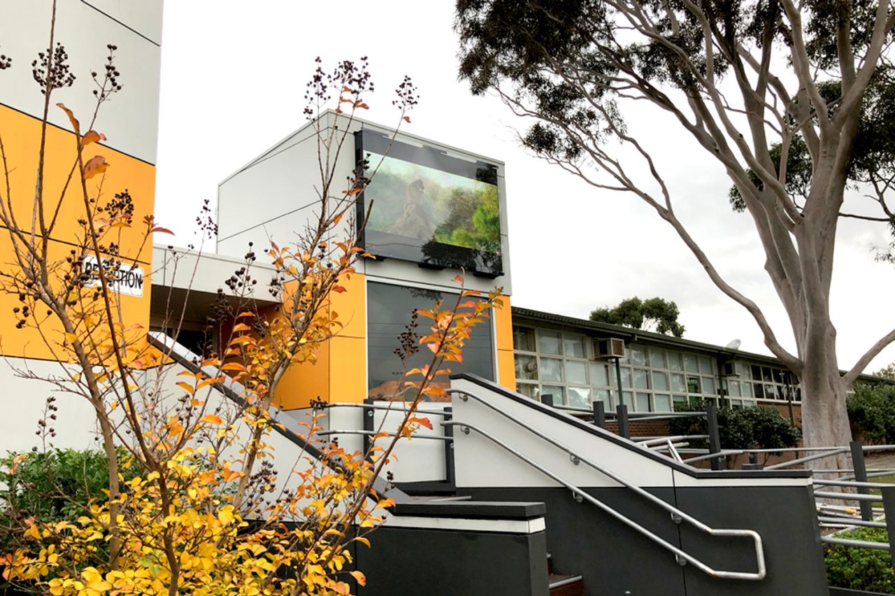Outdoor digital screen mounted on a school building at Wooranna Park Primary School.