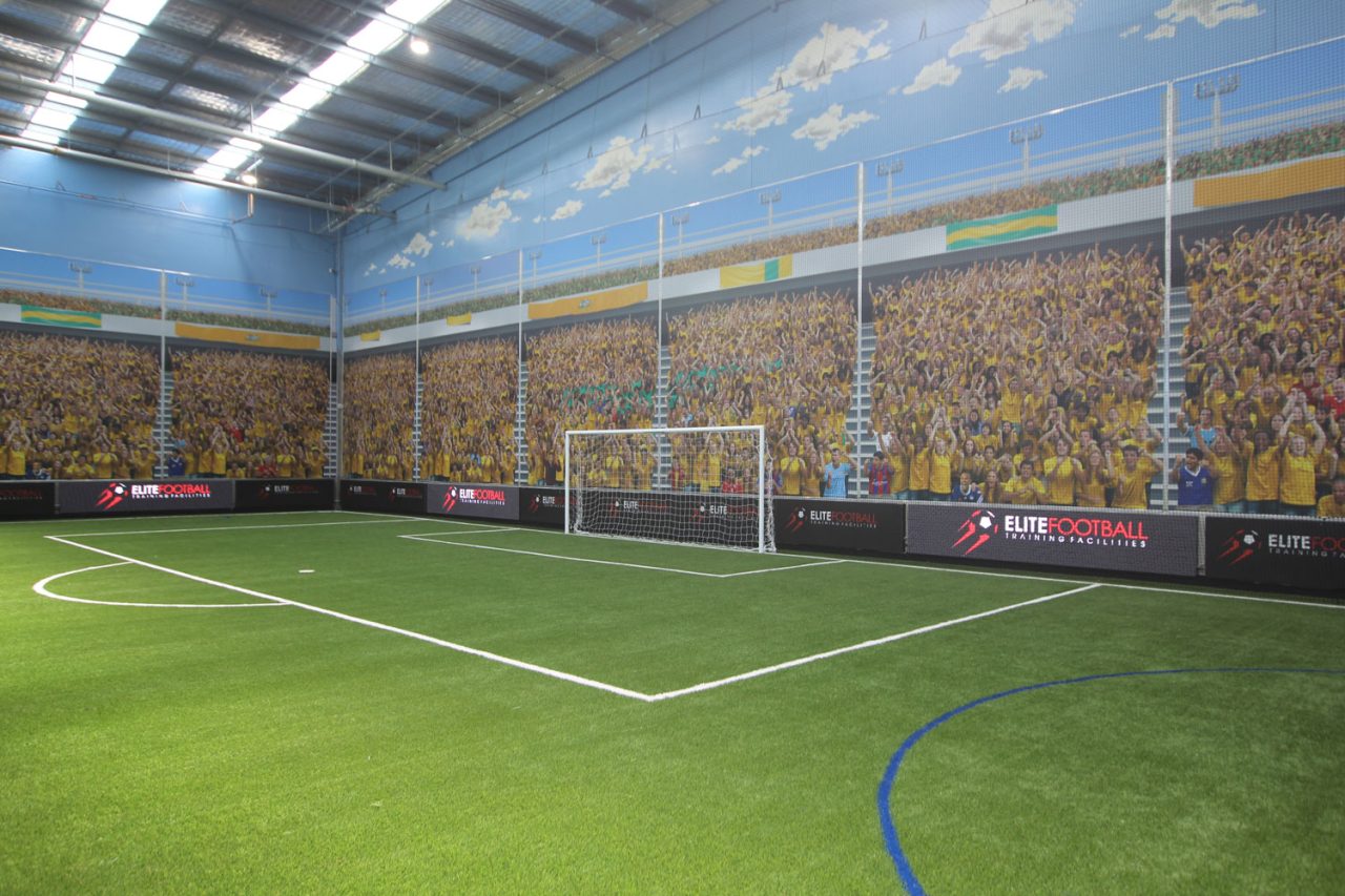 Digital perimeter displays around a corner of the indoor football pitch.