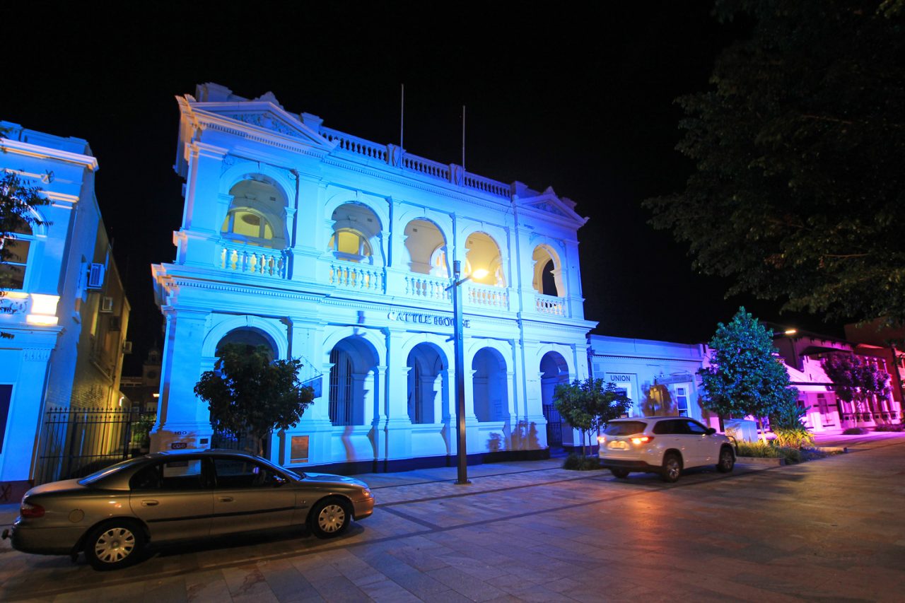 Blue illumination across an arched heritage building in Rockhampton's riverside precinct.