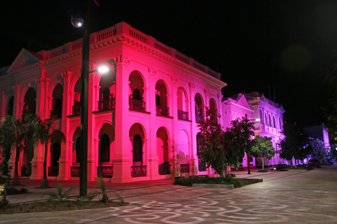 Red lighting across a two-storey heritage facade in Rockhampton's riverside precinct.