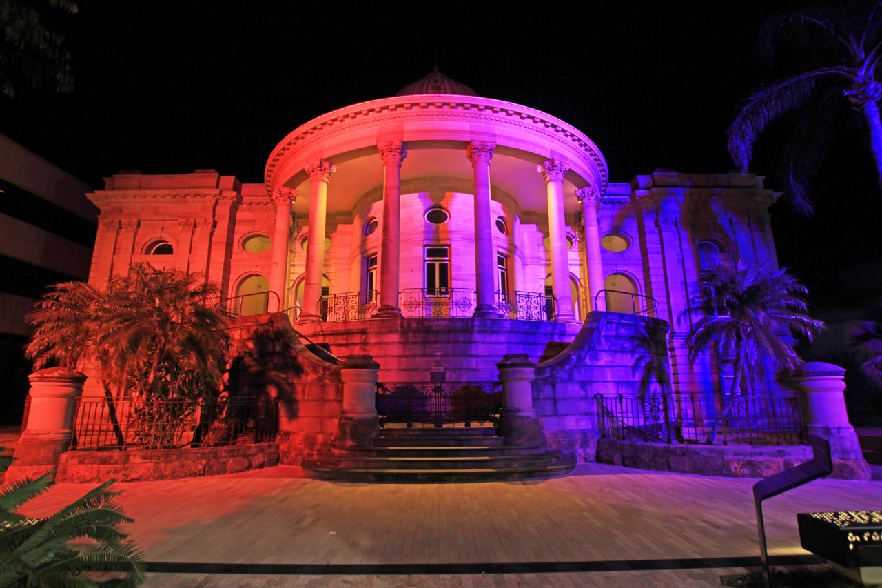 Red and purple lighting around a circular colonnaded building in Rockhampton's riverside precinct.