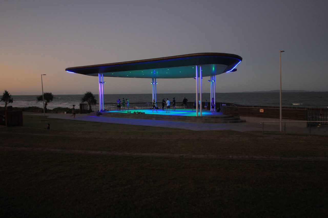 Blue and green lighting across the Yeppoon amphitheatre stage at dusk.