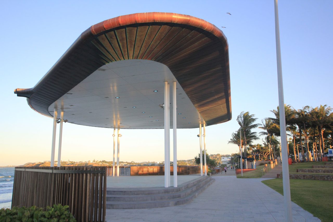 The curved roof and open stage of Yeppoon beachfront amphitheatre in daylight.