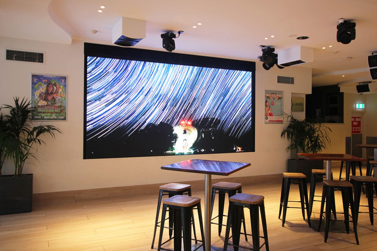 Night-sky imagery on the LED screen above tables at Melbas on the Park.