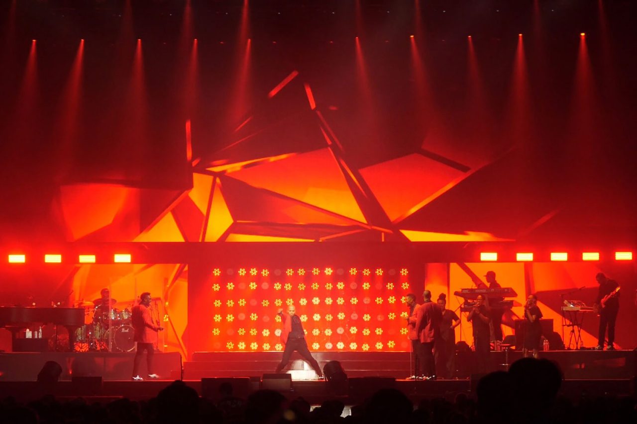 Red-lit stage and geometric screen graphics at Mariah Carey's Bangkok show.