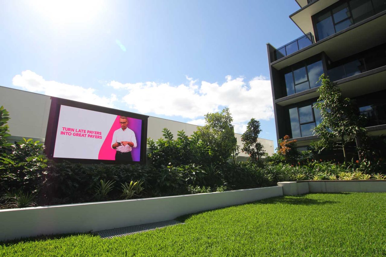 Advertising on the outdoor screen beside the Newstead North lawn.