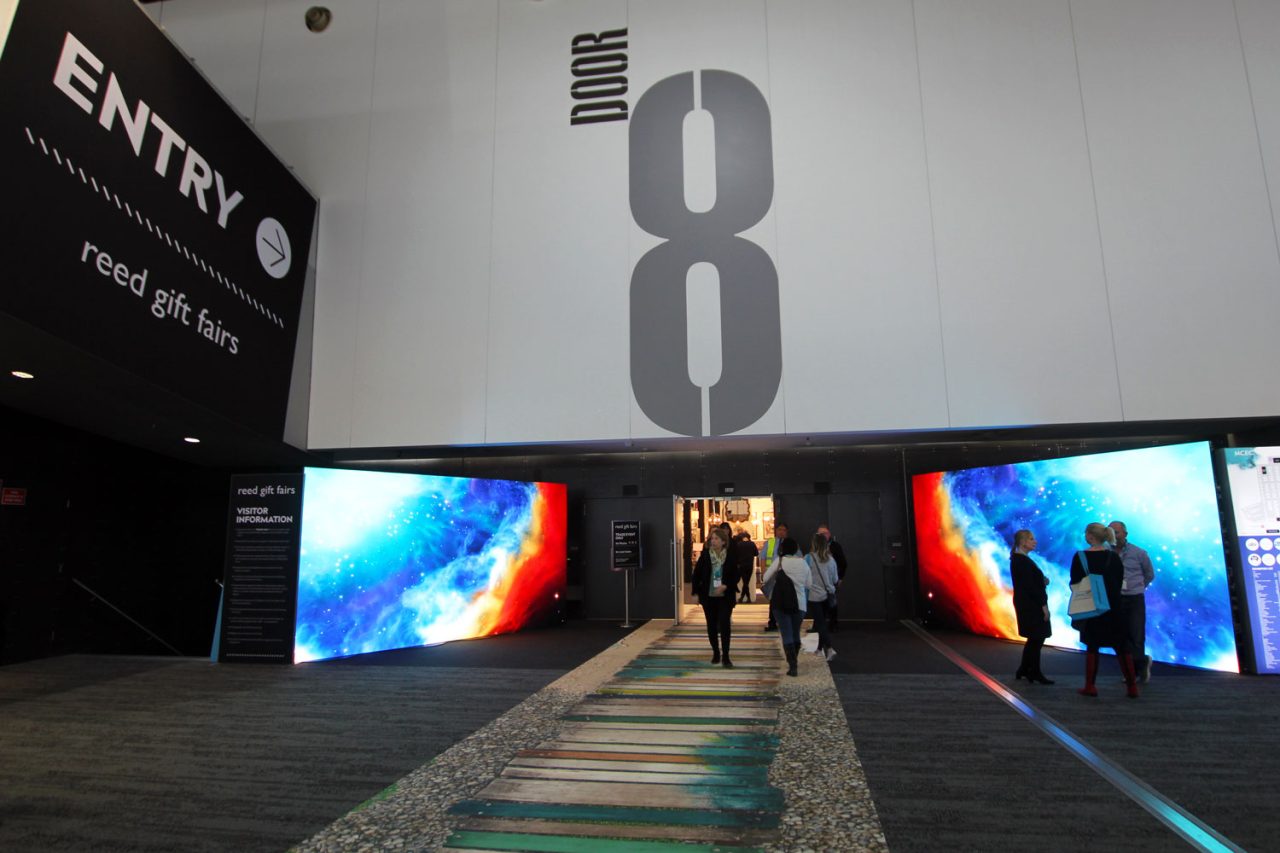 Visitors entering door eight between colourful LED displays at Reed Gift Fairs.