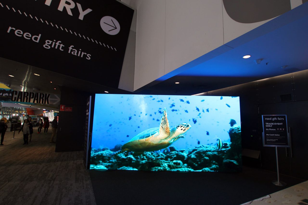 Underwater fish imagery on a large LED screen at the Reed Gift Fairs entrance.
