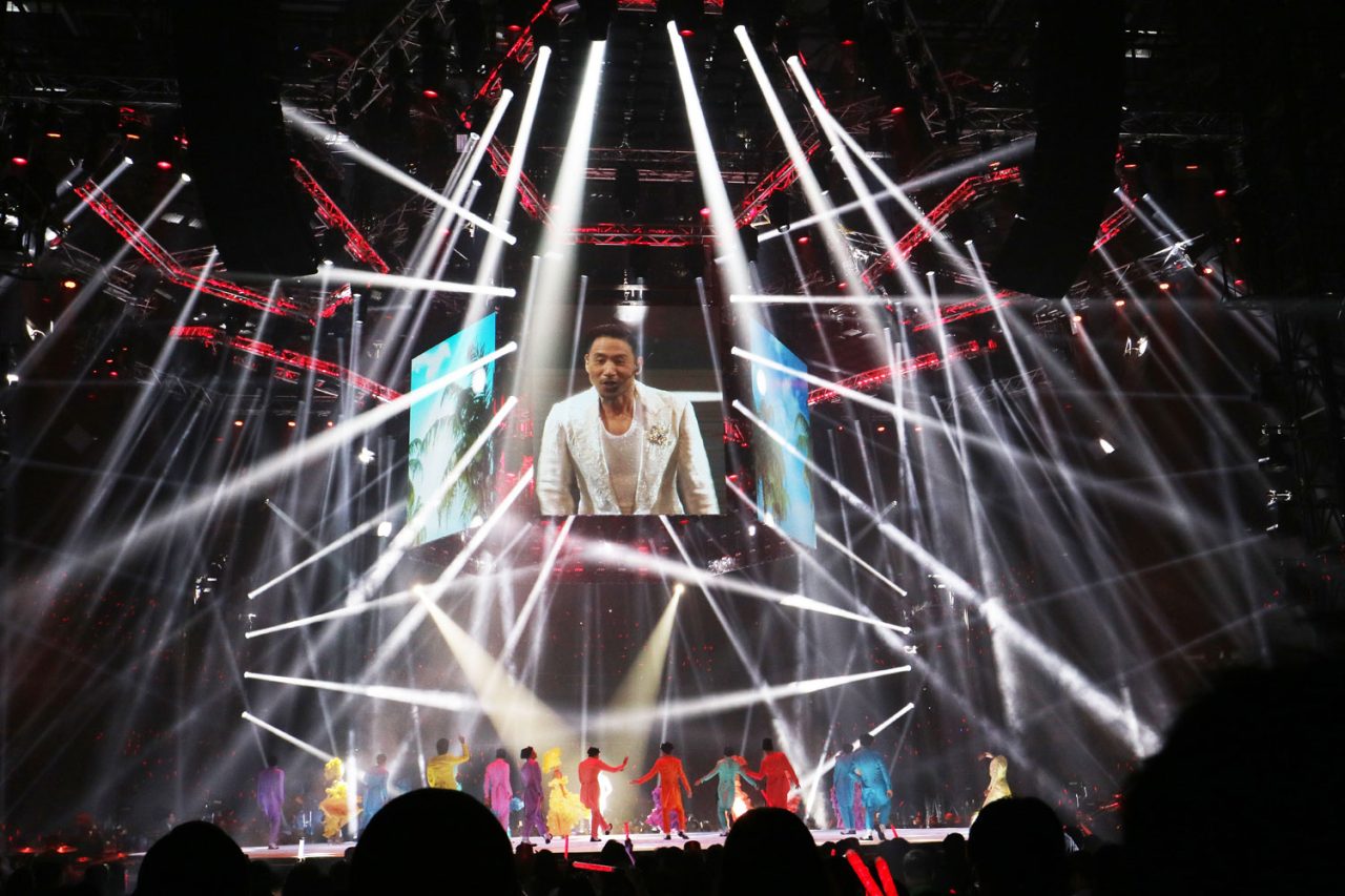 Jacky Cheung shown on a suspended screen inside a canopy of white beams.