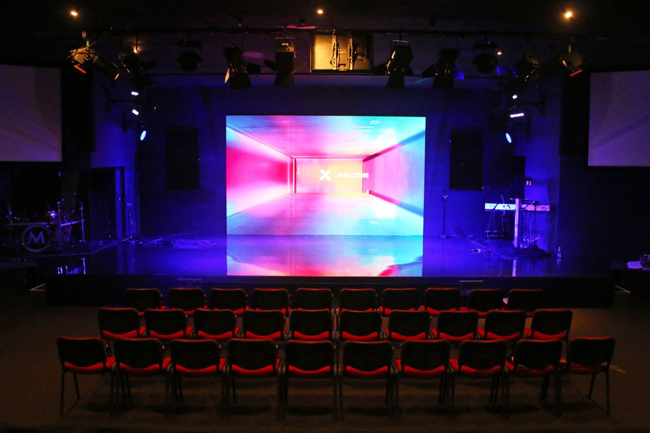 Colourful geometric imagery on the Metro Church stage screen.
