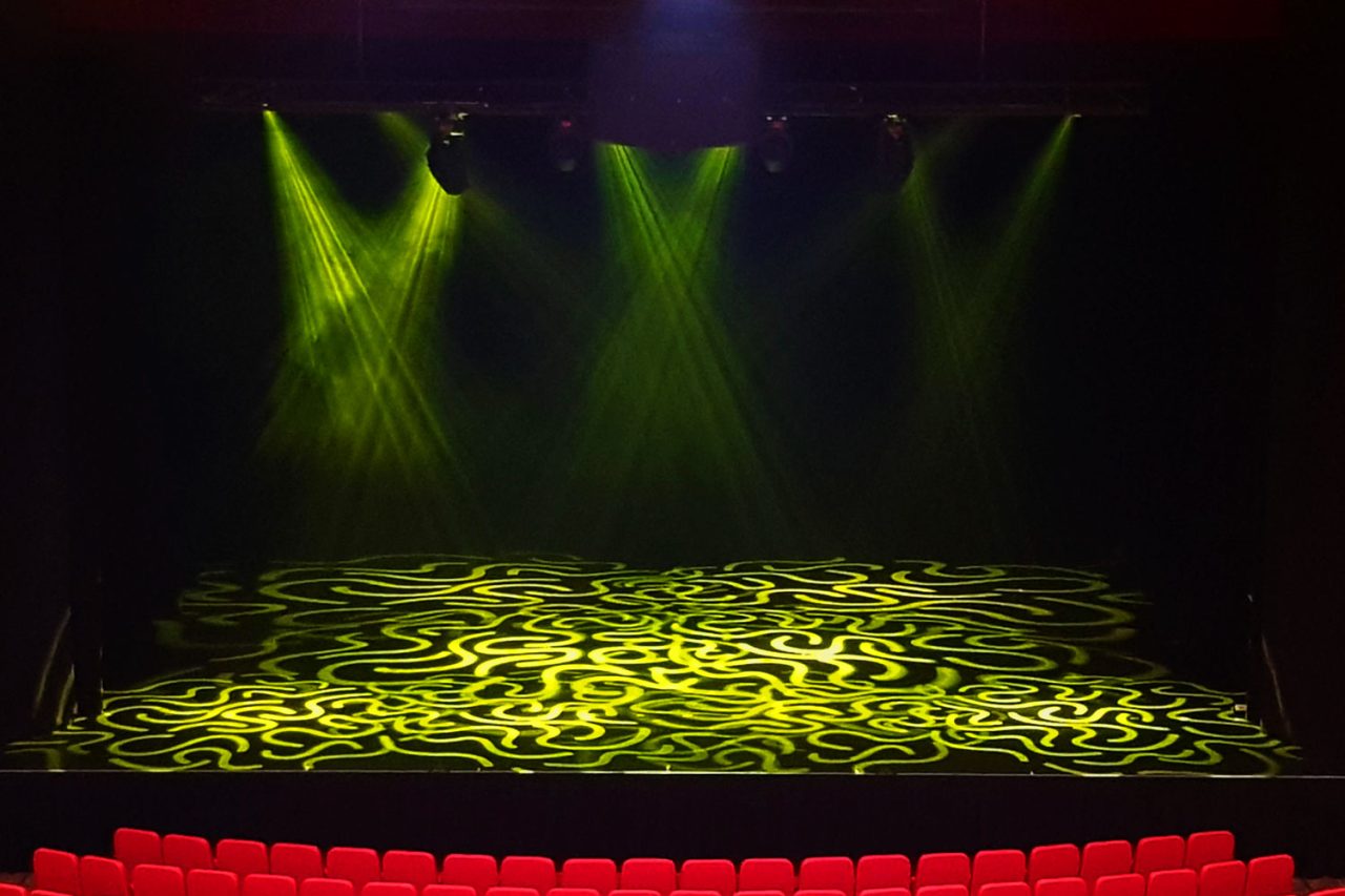 Green spotlights and patterned floor lighting on the Townsville Civic Theatre stage.