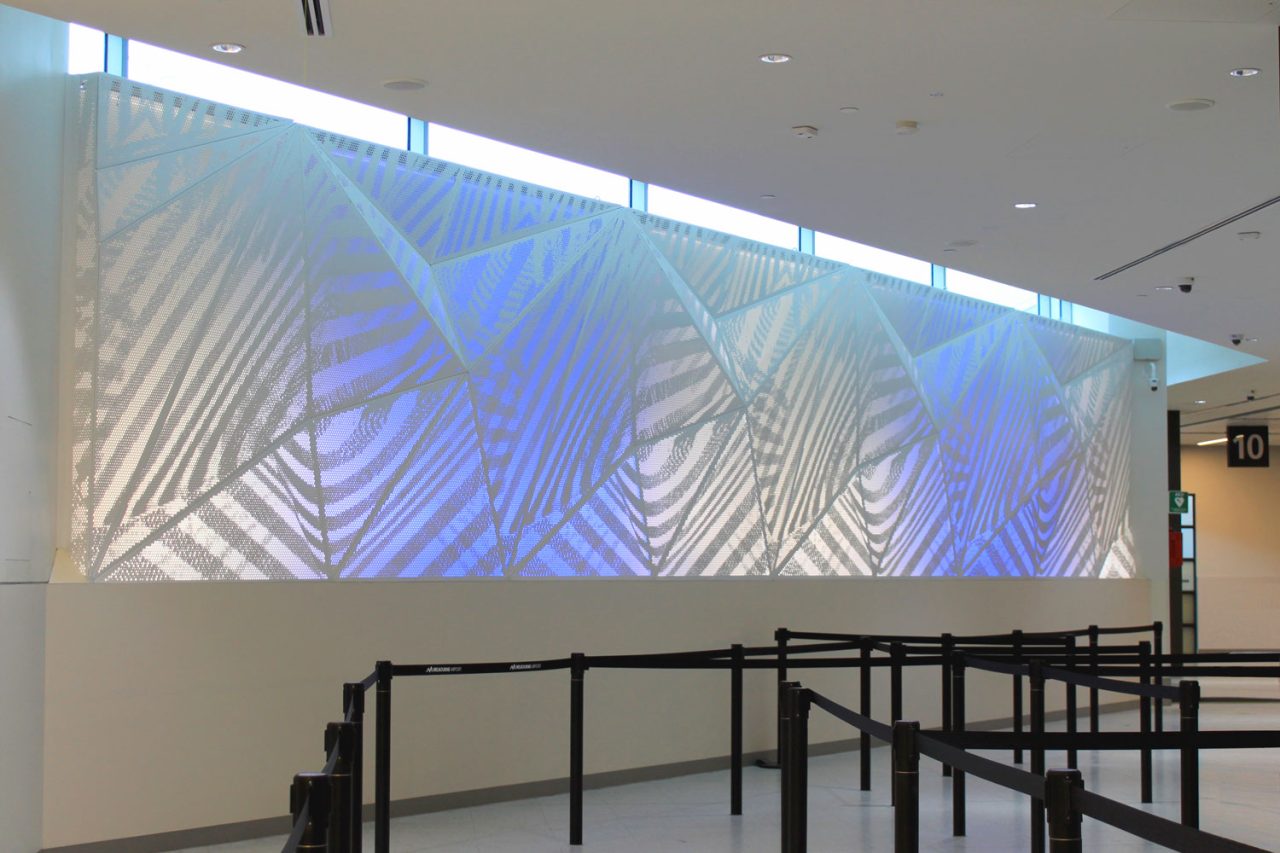 Traverse artwork by Britt Salt illuminated in pale blue at Melbourne Airport.