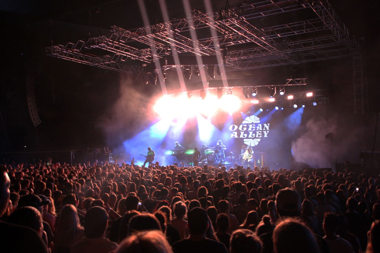 Crowd facing Ocean Alley's stage under white spotlights.