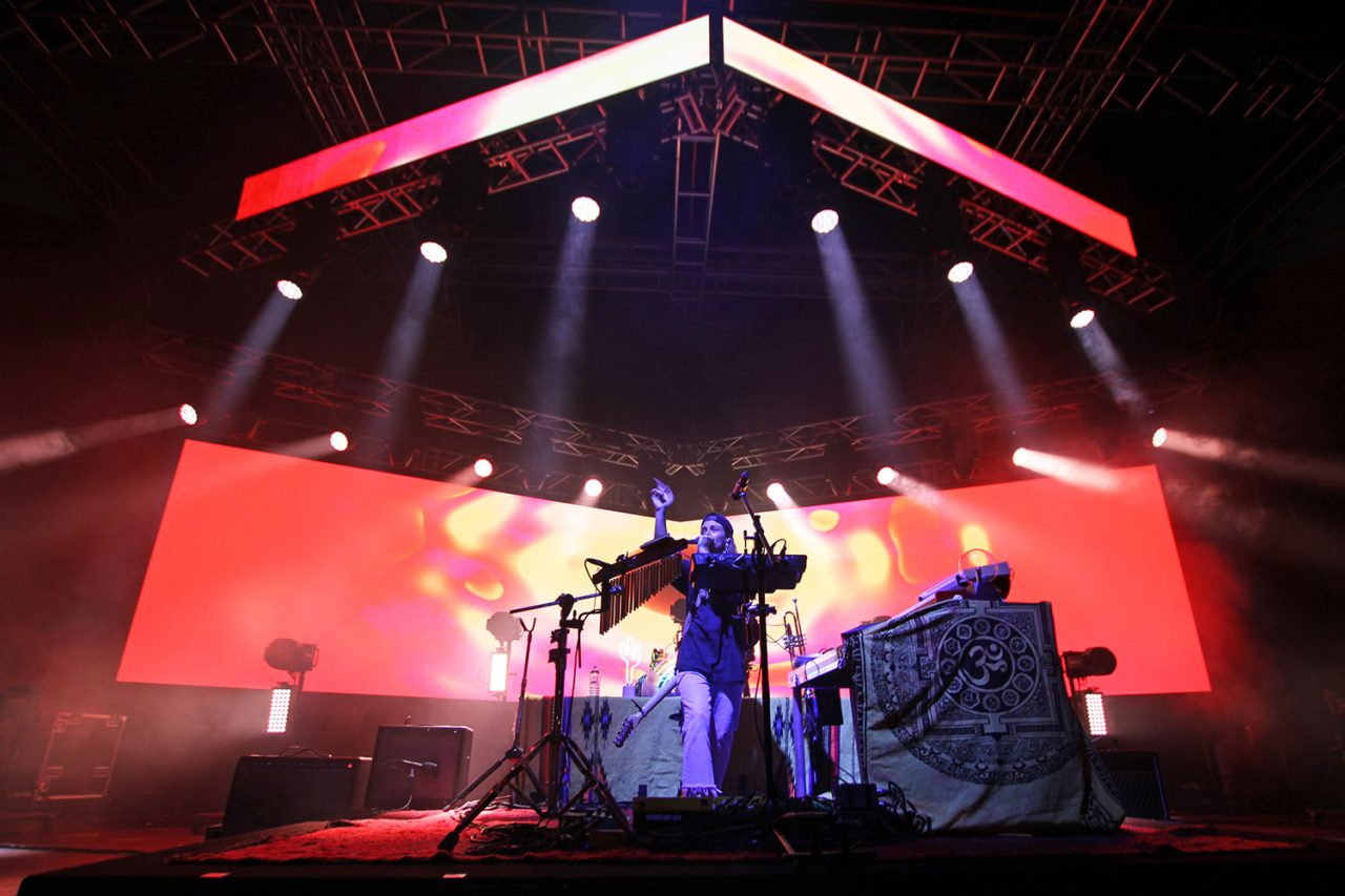 Red and pink imagery across the video backdrop on the Flow State tour.