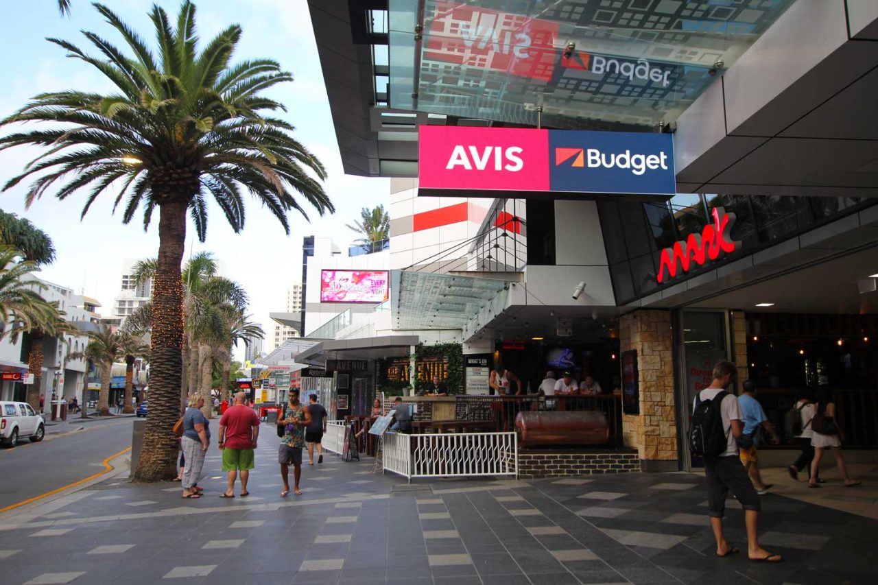 Avis and Budget advertising on a screen above The Mark's shopping walkway.