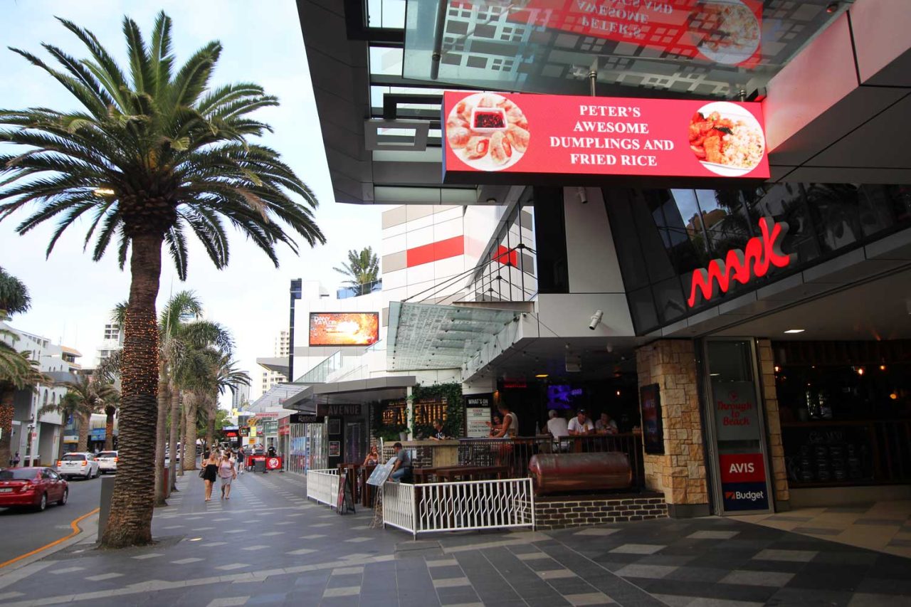 Digital advertising above pedestrians on The Mark's covered shopping walkway.