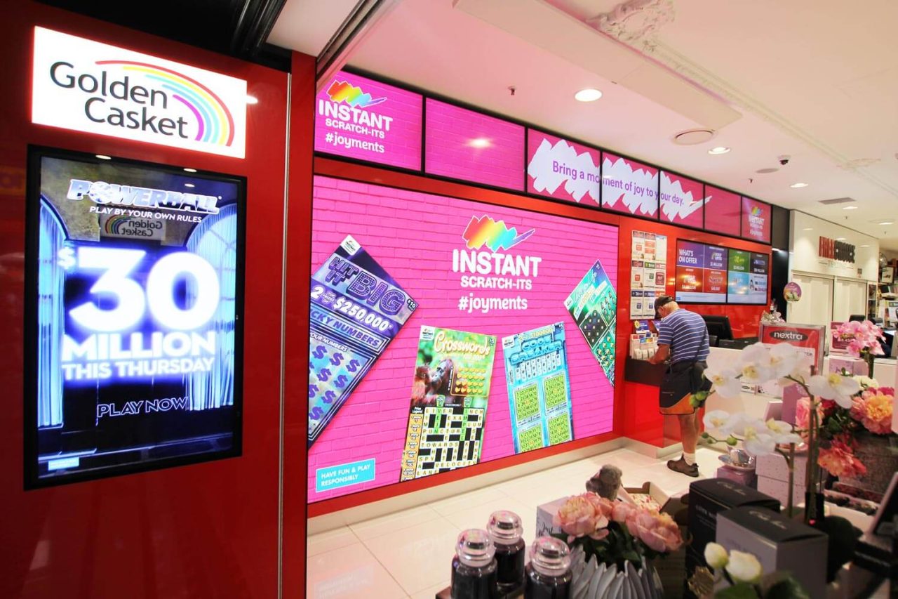 Colourful lottery promotions on digital screens inside the nextra Queen Street Mall store.