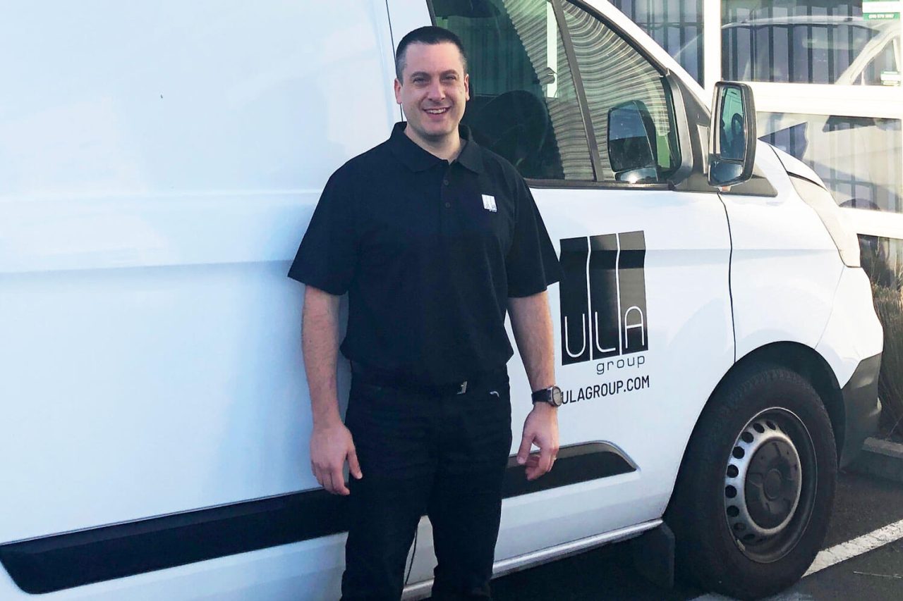 Closer portrait of Sean Rosig beside a ULA Group van.