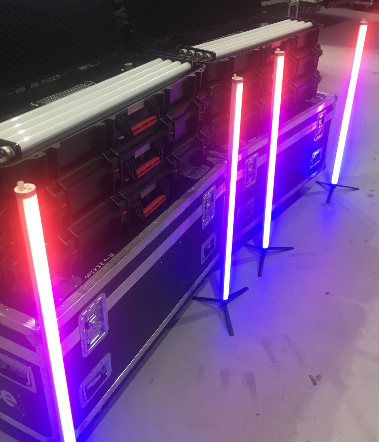 Astera tubes illuminated in pink and blue beside open equipment cases.