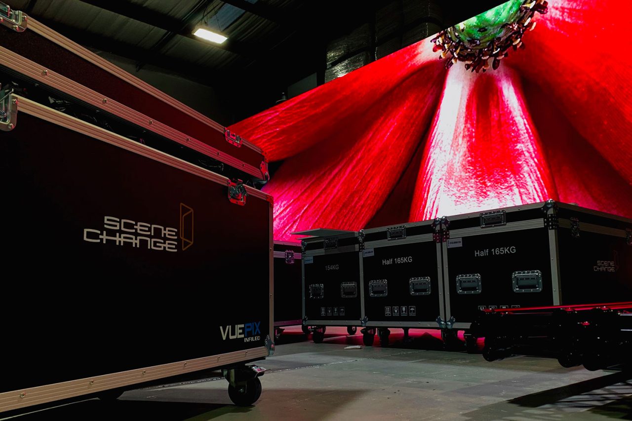 Red imagery on a large VuePix screen behind Scene Change flight cases.