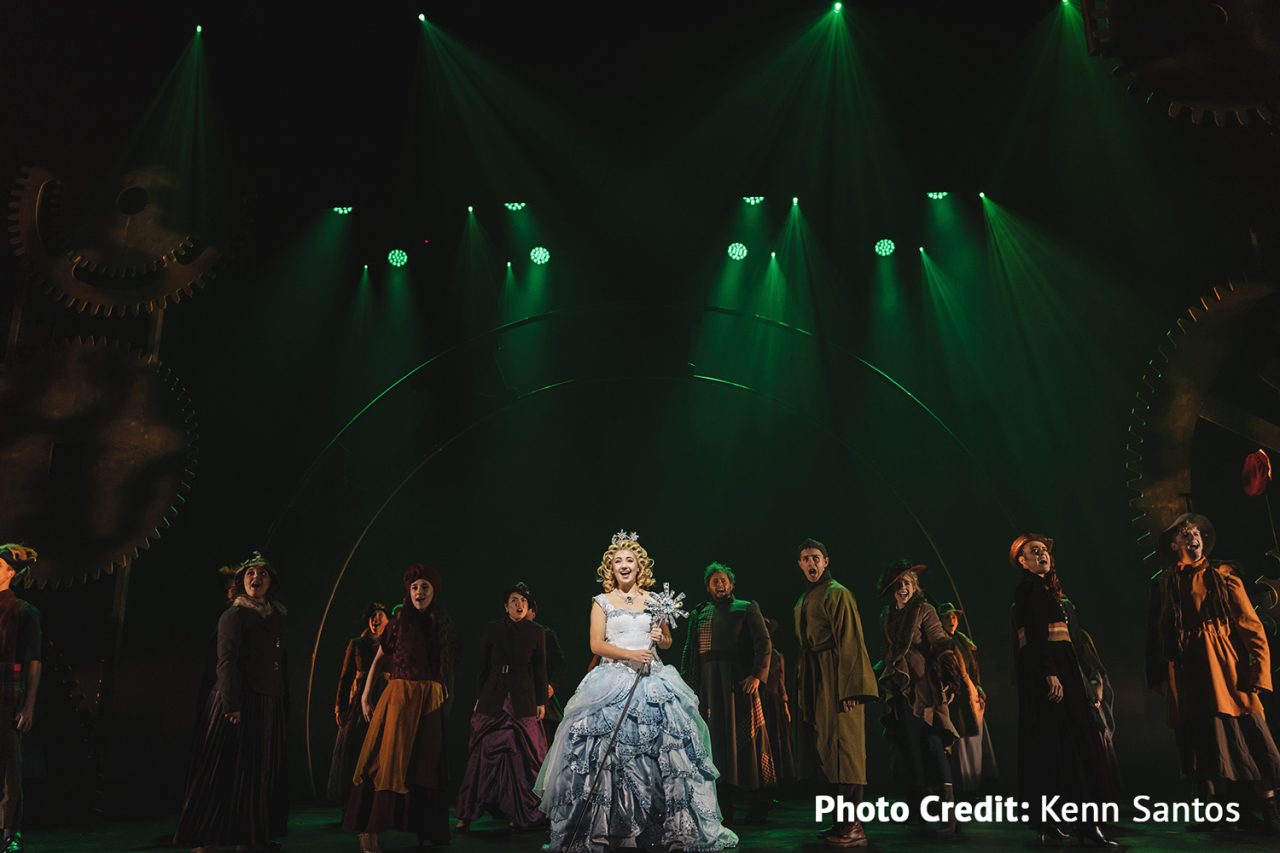Wicked cast beneath green spotlights on the HOTA stage.