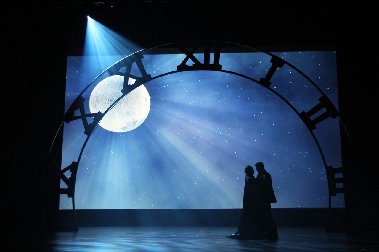 A silhouetted performer beneath a moonlit backdrop in Wicked at HOTA.