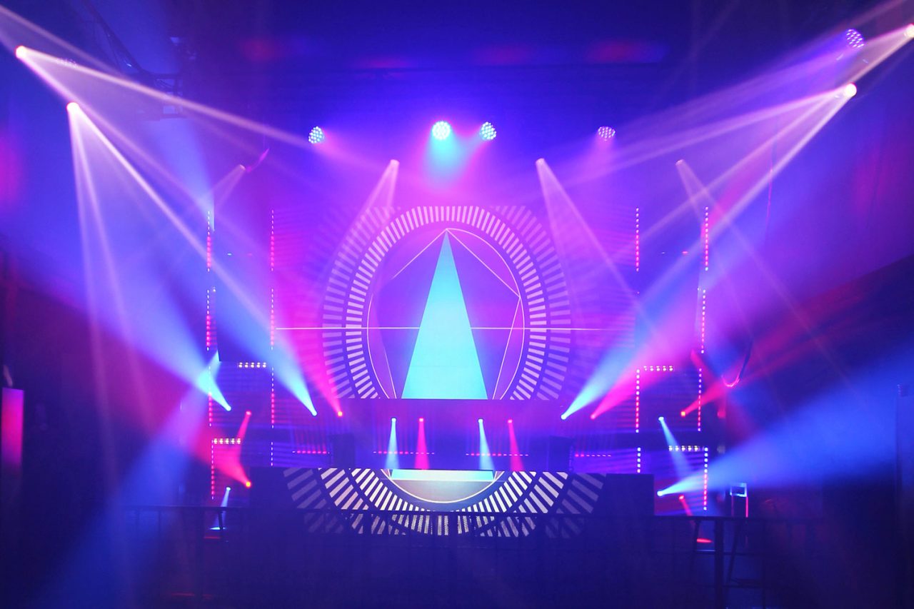 Purple beams and geometric screen graphics behind the FCTN stage.