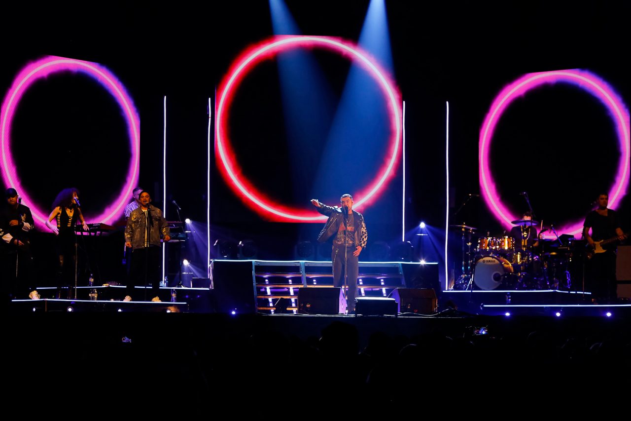 Pink ring graphics across three screens on the Ridin' With You tour stage.