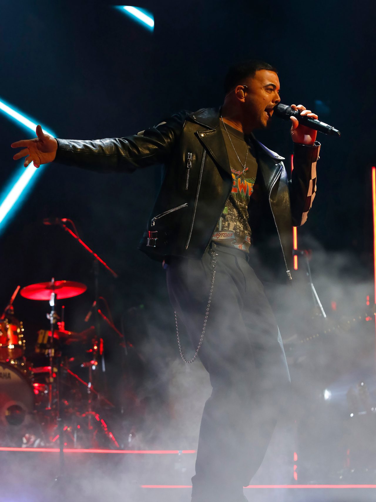 Vocalist at the front of the Ridin' With You stage amid low fog.