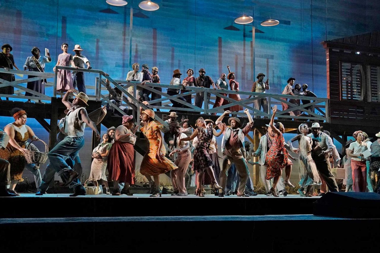 Wide view of the Porgy and Bess ensemble on a blue-lit multilevel stage.