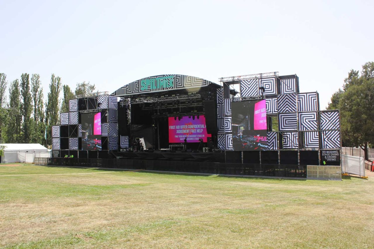 Spilt Milk stage and side screens viewed across an empty lawn before the show.