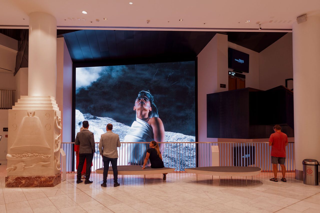 Visitors stand before the large digital artwork in the Aotea Centre foyer.